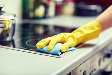 Image showing close up of woman cleaning cooker at home kitchen