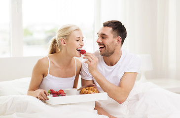 Image showing happy couple having breakfast in bed at home