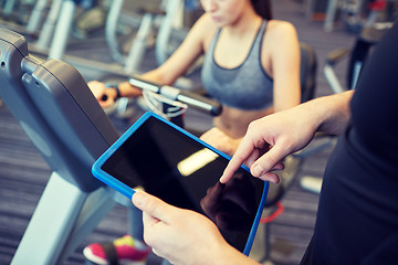 Image showing close up of trainer hands with tablet pc in gym