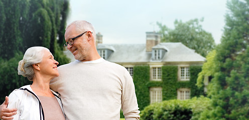 Image showing senior couple hugging over living house background