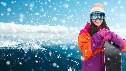 Image showing happy young woman with snowboard over mountains