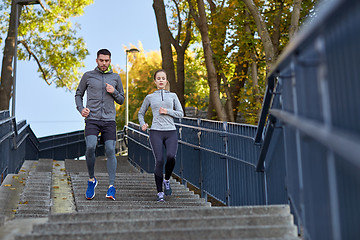 Image showing couple running downstairs in city