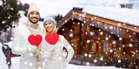 Image showing happy couple in winter clothes with heart outdoors