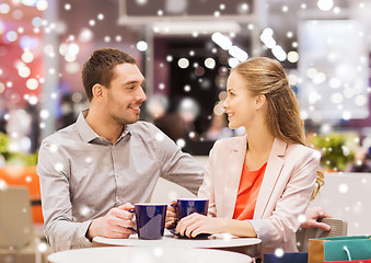 Image showing happy couple with shopping bags drinking coffee