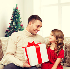 Image showing smiling father and daughter with gift box