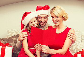 Image showing smiling family reading postcard