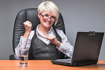 Image showing Angry businesswoman working with laptop in office