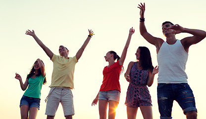 Image showing smiling friends dancing on summer beach