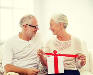 Image showing happy senior couple with gift box at home