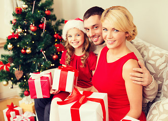 Image showing smiling family holding many gift boxes