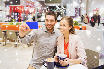 Image showing happy couple with smartphone taking selfie in mall