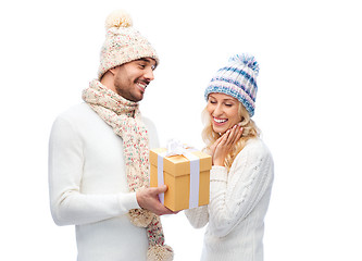 Image showing smiling couple in winter clothes with gift box