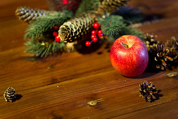 Image showing close up of apple with fir decoration on wood