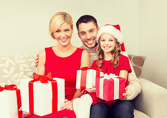 Image showing smiling family holding many gift boxes