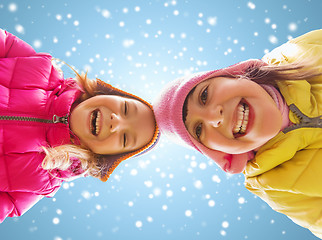 Image showing happy little girls faces over blue sky and snow