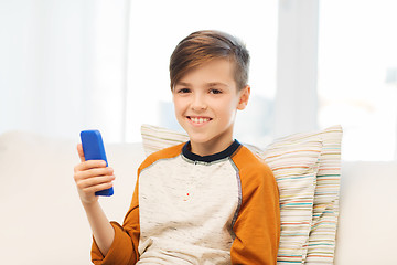 Image showing boy with smartphone texting or playing at home