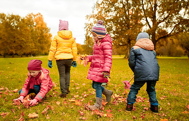 Image showing group of children collecting leaves in autumn park