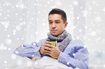 Image showing ill man with flu drinking hot tea from cup at home