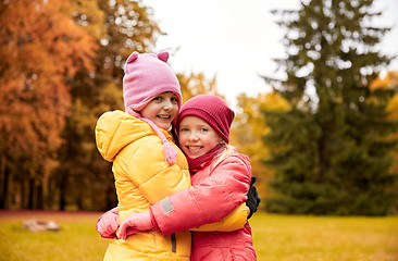 Image showing two happy little girls hugging in autumn park