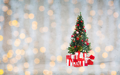 Image showing christmas tree with gifts over concrete wall