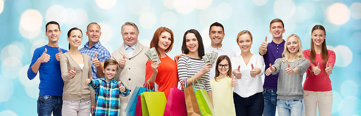 Image showing happy people with shopping bags showing thumbs up