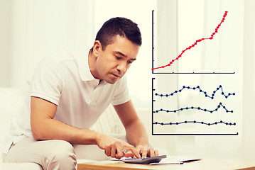 Image showing man with papers and calculator at home