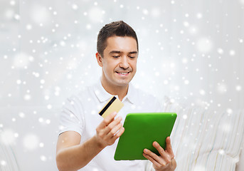 Image showing smiling man working with tablet pc and credit card