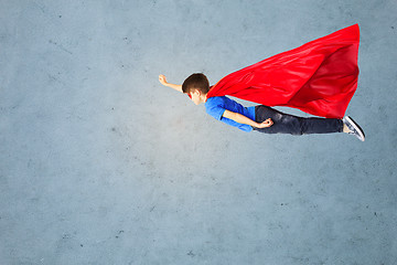 Image showing boy in red superhero cape and mask flying on air