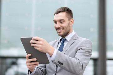 Image showing smiling businessman with tablet pc outdoors