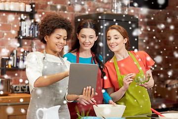 Image showing happy women with tablet pc cooking in kitchen