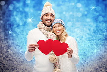 Image showing smiling couple in winter clothes with red hearts