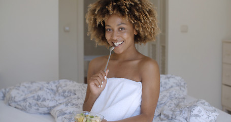 Image showing Young Woman On Bed Eating Vegetable Salad