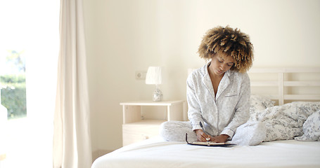 Image showing Girl Writes A Diary In Bed