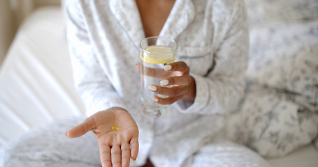 Image showing Woman Taking Pills On The Bed.