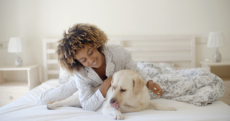 Image showing Woman Is Holding A Dog On A Bed