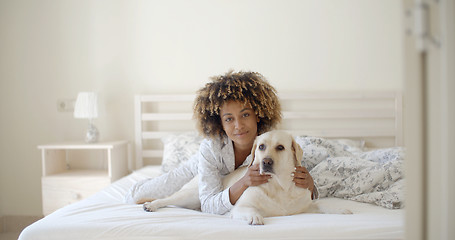 Image showing Woman Is Holding A Dog On A Bed