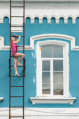 Image showing Pretty woman in pink on fire escape stair