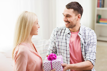 Image showing happy man giving woman gift box at home