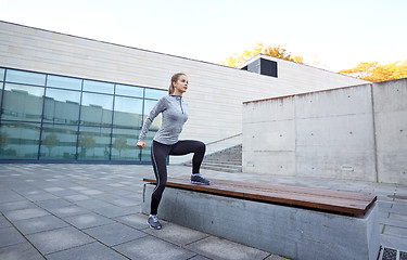 Image showing woman exercising on bench outdoors