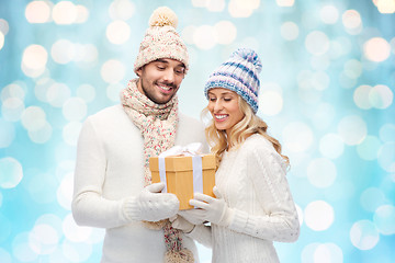 Image showing smiling couple in winter clothes with gift box