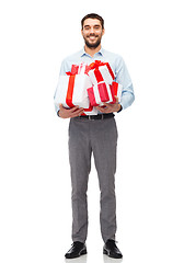 Image showing happy young man holding gift boxes