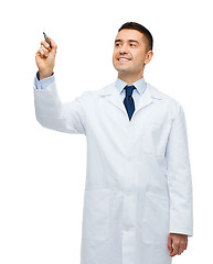 Image showing smiling male doctor writing something with marker