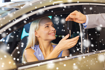 Image showing happy woman getting car key in auto show or salon