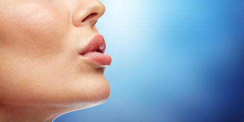 Image showing close up of young woman lips over blue