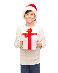 Image showing smiling happy boy in santa hat with gift box