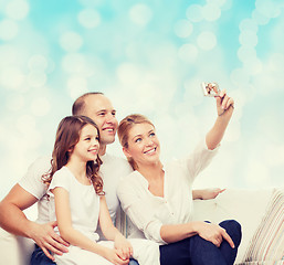 Image showing happy family with camera at home