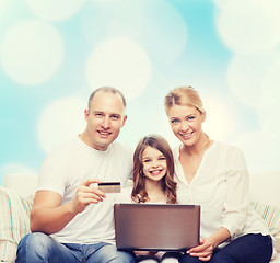 Image showing happy family with laptop computer and credit card