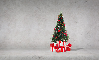 Image showing christmas tree with gifts over concrete wall