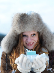 Image showing portrait of  girl with gift at winter scene and snow in backgron