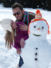 Image showing portrait of happy young couple with snowman